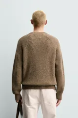 Sweater de punto perlado botonato en color marrón, corte regular fit, con cuello redondo y manga larga.