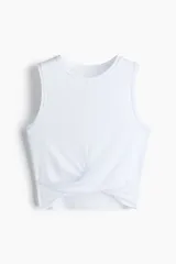 Top deportivo blanco, corte cropped y ajustado, sin mangas y con cuello redondo. Presenta un detalle de nudo o torcido en el bajo frontal.
