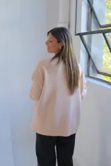 Sweater de tejido de punto color crudo, con cuello redondo, mangas largas y diseño holgado con aberturas laterales en el ruedo.