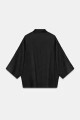 Camisa amplia confeccionada en hilatura con lyocell y ramio, color celeste, con cuello solapa, manga por debajo del codo, detalle de pliegue en la espalda y cierre frontal con botones ocultos por solapa.