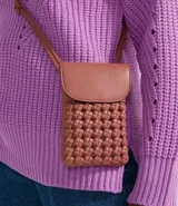 Cartera porta teléfono color rosado, con correa larga para colgar y diseño trenzado.