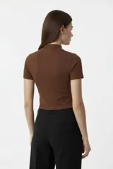 Remera de algodón y elastano, de corte ajustado al cuerpo, con cuello alto y mangas cortas.