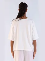 Remera de manga corta y cuello redondo, color blanco, con diseño holgado y confeccionada en algodón.