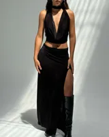 Falda larga negra con tajo lateral y top halter a juego.