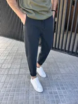 Pantalón jeans de corte slouchy, color negro gastado, suelto en la parte superior y ligeramente ajustado hacia los tobillos.