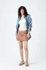 Minifalda color beige estilo cargo, de tiro bajo y corte recto, con bolsillos laterales.