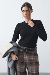 Sweater de tejido tipo rib, color negro, con cuello redondo y mangas largas. Presenta una textura acanalada y un ajuste al cuerpo.
