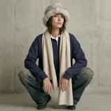 Sombrero tipo bucket de piel sintética en tono beige con textura afelpada.