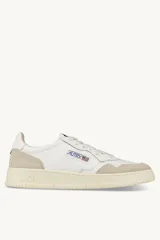 Zapatillas urbanas Autry Medalist Low para hombre, de cuero blanco y gamuza color crema. Diseño vintage de los años 80 con puntera perforada, cordones planos de algodón, lengüeta de tela con etiqueta cosida, cuello acolchado y suela de goma con logo.