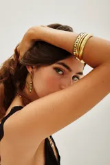 Set de pulseras rígidas de metal dorado, compuesto por tres piezas con diferentes texturas y diseños grabados.