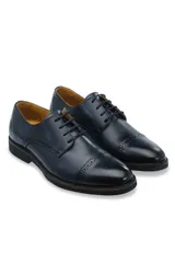 Zapato de vestir tipo oxford color marrón, confeccionado en cuero, con detalles de costura tipo brogue en la puntera y laterales, cordones al tono y suela robusta de goma.
