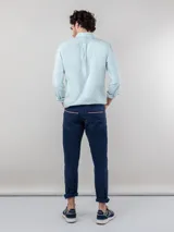 Camisa celeste de corte clásico, con cuello abotonado, manga larga y logo bordado en el pecho.