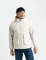 Campera impermeable negra con capucha, cierre frontal, bolsillos frontales con tapa y puños elásticos.