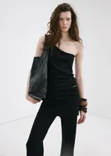 Pantalón de punto fino color negro, de diseño recto y tiro medio, con falda corta superpuesta integrada.