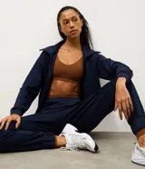 Pantalón deportivo tipo jogger color bordó, confeccionado en tejido de modal con poliéster y elastano. Presenta cintura fija, recortes estratégicos en el diseño y terminación ajustada en la botamanga.