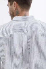 Camisa celeste a rayas verticales blancas, de manga larga y corte clásico.