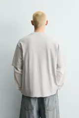 Camiseta relaxed fit color beige con cuello redondo y manga corta. Presenta un estampado frontal de un cartón de leche de fresa con una pajita, texto en japonés y la frase "SWEET MOMENTS".