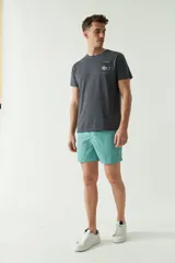 Short de baño liso con cintura elástica y cordón ajustable. Cuenta con dos bolsillos laterales, un bolsillo trasero y logo bordado. Confeccionado en tela ligera de secado rápido.