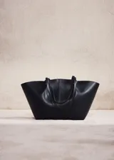 Bolso shopper negro de efecto piel, con dos asas de hombro, detalles metálicos, cierre de botón magnético y bolsillo interior con cremallera.