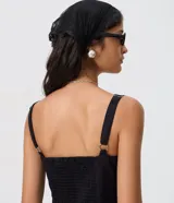 Vestido midi asim&eacute;trico de color negro, con escote cuadrado, breteles anchos regulables y panel frontal superpuesto.