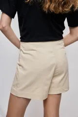 Short cruzado de tiro medio con diseño frontal tipo falda, color negro, de líneas simples y calce cómodo.