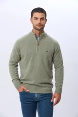 Buzo tejido de lana con cuello alto y medio cierre metálico frontal. Presenta puños y ruedo acanalados, con logo bordado en el pecho.