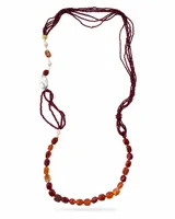 Collar largo de diseño asimétrico compuesto por múltiples tiras finas de abalorios bordó, combinado con piedras naturales de cornalina en tonos rojizos y naranjas, perlas barrocas blancas y detalles metálicos dorados.