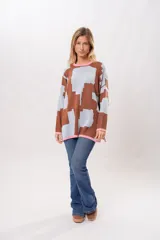 Buzo oversize de algodón con estampado geométrico en tonos marrones y celestes, con cuello y puños en color rosa.