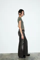 Camiseta de corte entallado confeccionada en mezcla de algodón, con cuello redondo y mangas cortas. Presenta un diseño básico de bajo recto en color gris oscuro.