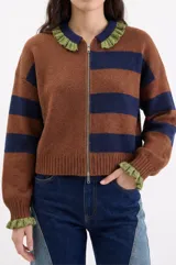 Cardigan de tejido de punto con diseño a rayas horizontales en tonos marrón y azul marino. Presenta cierre frontal con doble cursor, cuello tipo polo con detalles en hilo metalizado dorado y puños con el mismo acabado brillante.