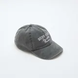 Gorra tipo baseball de algodón con efecto lavado, color negro, con bordado frontal en color blanco que incluye texto decorativo.