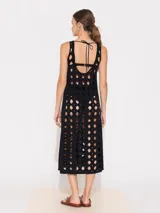 Vestido negro midi con aberturas geométricas y tiras finas.