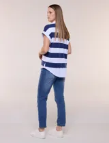 Remera holgada con diseño two-fold que simula efecto superpuesto con una camisa blanca inferior. Presenta cuello polo, escote en V y rayas horizontales beige y blancas.