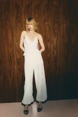 Top blanco con lentejuelas, cuello halter y escote fluido.