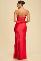 Vestido largo de satén rojo con paneles de mesh transparente estratégicamente ubicados. Presenta escote en V con breteles finos y una silueta fluida que se ajusta al cuerpo.