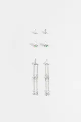 Set de tres pares de caravanas plateadas con diseño de estrella. Incluye un par pequeño, un par con piedra verde central y un par colgante con cadenas finas.