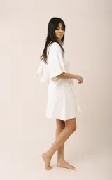 Bata corta de algodón con diseño envolvente, escote en V y mangas amplias. Incluye un lazo ajustable en la cintura para un calce adaptable.