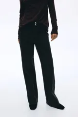 Jean de denim de algodón con leve stretch, de tiro alto y corte wide leg. Presenta cierre frontal con doble botón, bolsillos traseros de parche y pliegues marcados en la parte delantera y trasera.