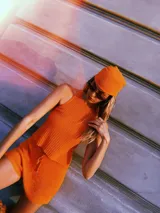 Blusa de punto color naranja con lurex, modelo halter y escote redondo.