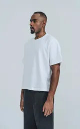 Remera de corte boxy con silueta amplia y recta, confeccionada en algodón premium. Presenta cuello redondo y mangas cortas con un calce relajado.