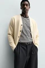 Cardigan regular fit de punto tejido en hilatura de algodón color marrón, con cuello en pico, manga larga, acabados en rib y cierre frontal de botonadura.