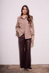 Camisa color marrón claro de gamuza vegana, corte oversize, con cuello clásico, cierre frontal con botones y mangas largas.
