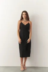 Vestido midi negro, cruzado estilo wrap, con escote en V y tirantes finos.