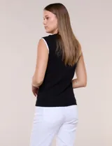 Blusa de punto fino azul marino sin mangas, con escote redondo y sisas decoradas con ribete festoneado blanco.