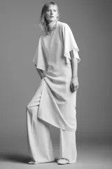 Vestido midi fluido de cuello alto y manga corta tipo capa. Presenta un diseño minimalista con bajo recto y aberturas laterales, con cierre en la espalda.