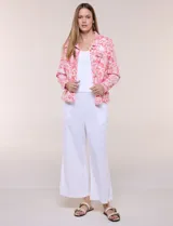 Camperita de lino liviana, marca Dash, con estampado botánico de hojas en tonos azules, verdes y tostados sobre base blanca. Presenta cierre frontal con botones, cuello clásico y bolsillos aplicados en el pecho.