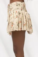 Minifalda con estampado floral, diseño de tiro alto con detalle de cordones frontales tipo corset y falda con volados.
