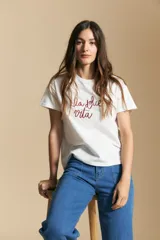 Remera de manga corta color marrón, con la frase "la dolce vita" bordada en azul en el frente y mangas con dobladillo.