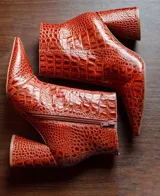 Botas cortas color marrón con estampado de cocodrilo, punta fina y taco de 8.5 cm.