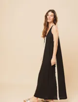 Vestido largo blanco de lino con escote en V y flecos de algodón en los bordes.